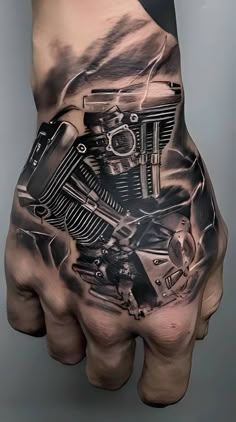 a man's hand with a tattoo on it and a motorcycle engine in the middle