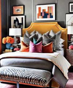 a bedroom with gray walls and pictures on the wall above the bed, along with zebra print foot stools