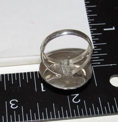 a silver ring sitting on top of a ruler