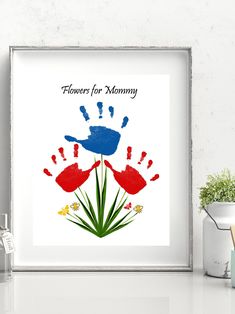 a framed print with the words flowers for mommy and handprints on it in red, blue and green