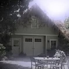 a table and chairs in front of a garage