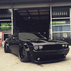 a black sports car parked in front of a garage