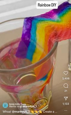 a rainbow colored toothbrush in a glass cup on a table with the words rainbow diy above it