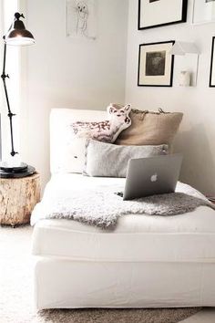 a laptop computer sitting on top of a white couch