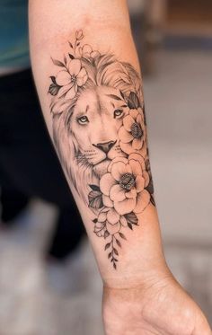 a woman's arm with a lion and flowers on it