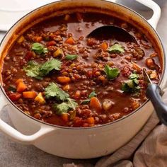 a pot filled with chili and vegetables on top of a table