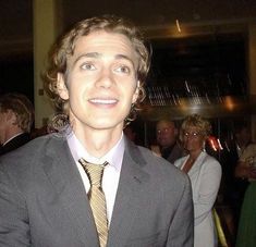 a young man in a suit and tie posing for the camera