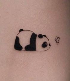 a small panda bear tattoo on the stomach