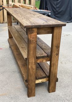 a wooden table sitting on top of a cement ground