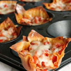 several mini pizzas are in a muffin tin