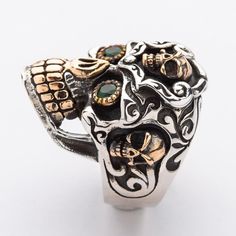 a silver ring with skulls and gems on it's sides, against a white background