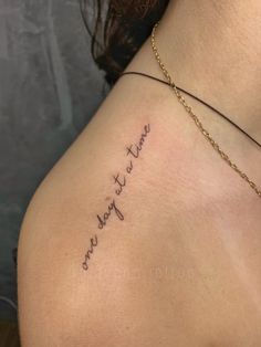 the back of a woman's shoulder with words written in cursive writing