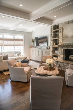 a living room filled with furniture and a fire place in the middle of a room