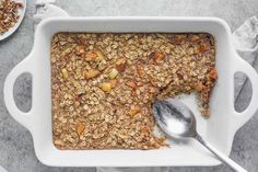 a white bowl filled with granola and two spoons