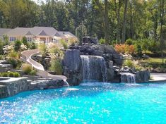 a pool with a waterfall and slide in the middle