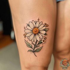 a woman's thigh with a flower tattoo on the side of her leg,