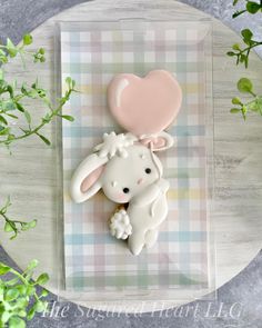 a cookie shaped like a bunny with a heart on it's back sitting on top of a table