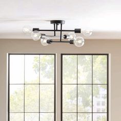 a living room with two windows and a ceiling light