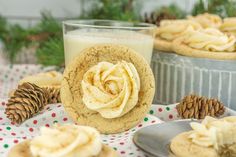 cookies with frosting and pine cones on a table next to a glass of milk