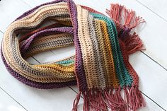 a multicolored scarf laying on top of a wooden floor