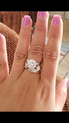 a woman's hand with two rings on it and one ring in the middle