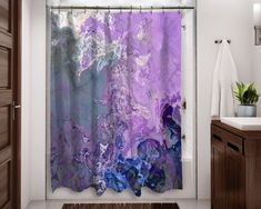 a shower curtain with purple and blue paint on it in a bathroom next to a sink