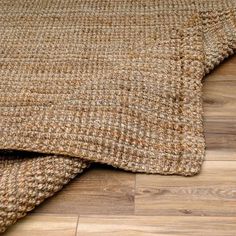 a close up view of a rug on the floor with wood floors in the background