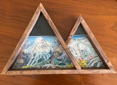 two wooden triangle shaped shelves with pictures on them, one has a mountain scene and the other is a ski area