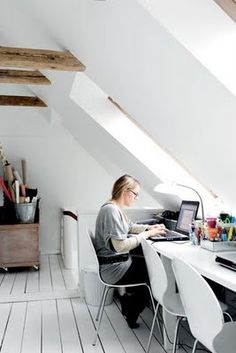 a woman sitting at a desk in an attic