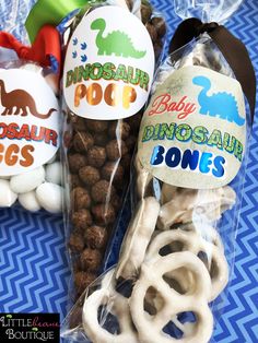 two bags of dinosaur bones are sitting on a blue and white tablecloth with an orange ribbon