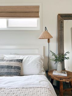 a bedroom with a bed, mirror and lamp