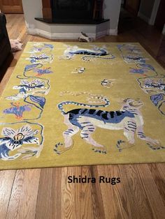 a yellow rug with blue and white cats on it