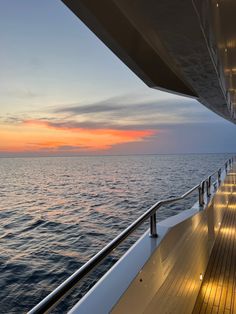 the sun is setting over the ocean on a boat