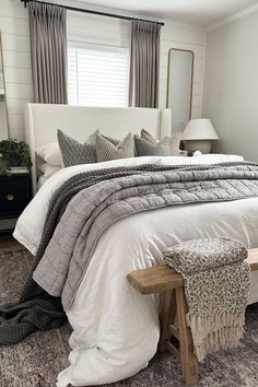 a white bed sitting in a bedroom next to a window