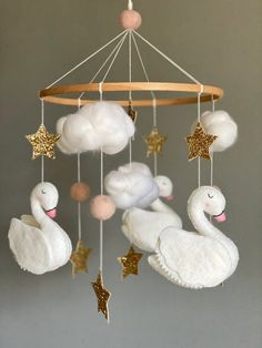 a mobile with swan and stars hanging from it