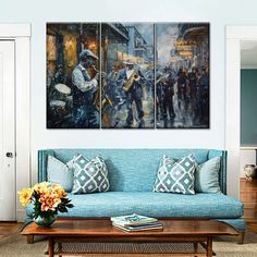 a living room with blue couches and paintings on the wall, including a coffee table