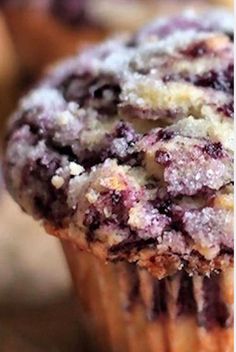 a blueberry muffin with powdered sugar on top is sitting on a table