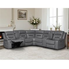 a large grey sectional sofa sitting on top of a white floor next to a fireplace