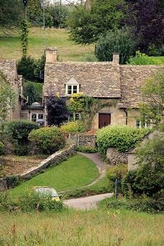 an old stone house surrounded by greenery and trees