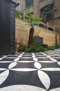 a black and white tiled floor next to a building