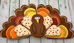 a decorated turkey cookie sitting on top of a wooden table