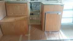 the inside of a camper with wood cabinets and drawers