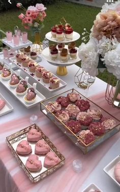 a table topped with lots of desserts on top of plates and trays filled with cupcakes