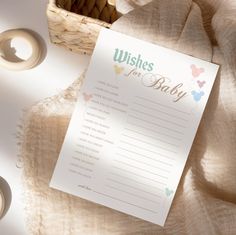 a baby wishes card sitting on top of a table next to a basket and candles