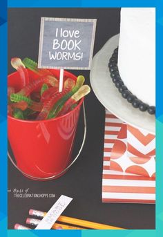 a red bucket filled with vegetables next to a white cake