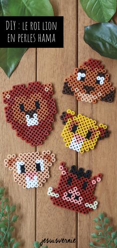 four small animals made out of perler beads on a wooden surface with leaves and greenery in the background