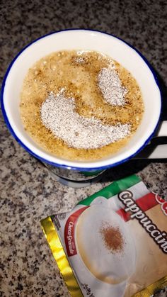 a cup of coffee with powdered sugar in it next to a bag of chips