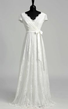 a white wedding dress on a mannequin with a bow at the waistline