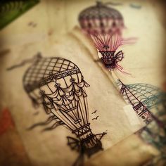 two drawings of hot air balloons are shown on the paper that has been drawn onto