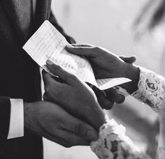 the bride and groom are holding each other's hands as they hold their wedding vows